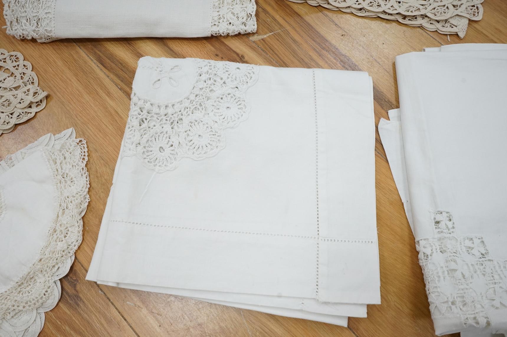 A collection of early 20th century and later crochet, cut work and drawn thread table linens and a large embroidered table cloth